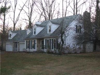 Center hall traditional: Living rm right, dining rm left, kitchen breakfast back left, beamed ceiling fireplaced family room back right.
Four beds & two bath up. Bonus rm above extra garage. Wooded site surrounds patio to back. See seller financing