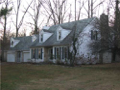 Center hall traditional: Living rm right, dining rm left, kitchen breakfast back left, beamed ceiling fireplaced family room back right.
Four beds & two bath up. Bonus rm above extra garage. Wooded site surrounds patio to back. See seller financing