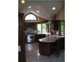 Kitchen: Ceramic tiled flooring. Raised ceilings, Indirect lighting. Solid surface counter tops. SS appliances. Solid cherry cabinets. Brkfst Peninsula bar counter and separate family dining area . Passage to formal dine, great room, deck & dock