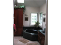 Stone flooring, corner window glass and steeping tub, skylight, quality wood vanity, wall sconce lighting, walk in closet, privacy water closet.