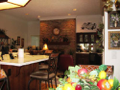 Masonry fireplace is gas log adapted, two sided, includes raised hearth, and flanked by integrated pass thru wet bar. Breakfast bar, hardwood flooring, raised ceiling height, indirect lighting, exit to exterior wood deck and back yard partial fenced