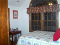 Bedroom 2: Arched window in vaulted ceiling. Large closet. Stained woodwork. Hardwood floor.