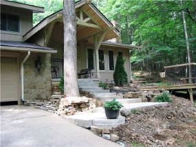 Exterior Front: Landscaped to include front deck, fieldstone retaining walls, entry concrete walk, sandstone walk path, covered entry timber porch. Aesthetically pleasing for plants and people.