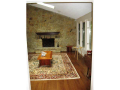 Great Room: Sandstone masonry fireplace with seating hearth. Vaulted ceilings with skylights. Hardwood floors. South window wall. At entry level with invitational access to front entry covered exterior porch and terraced deck. Balcony overlook from dine.